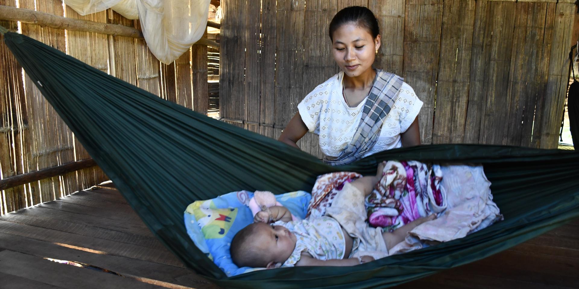 Naw Mu Lar watches over her baby, in their home on the Thai-Myanmar border, protected from mosquito bites and the risk of malaria. Photo: ARHC