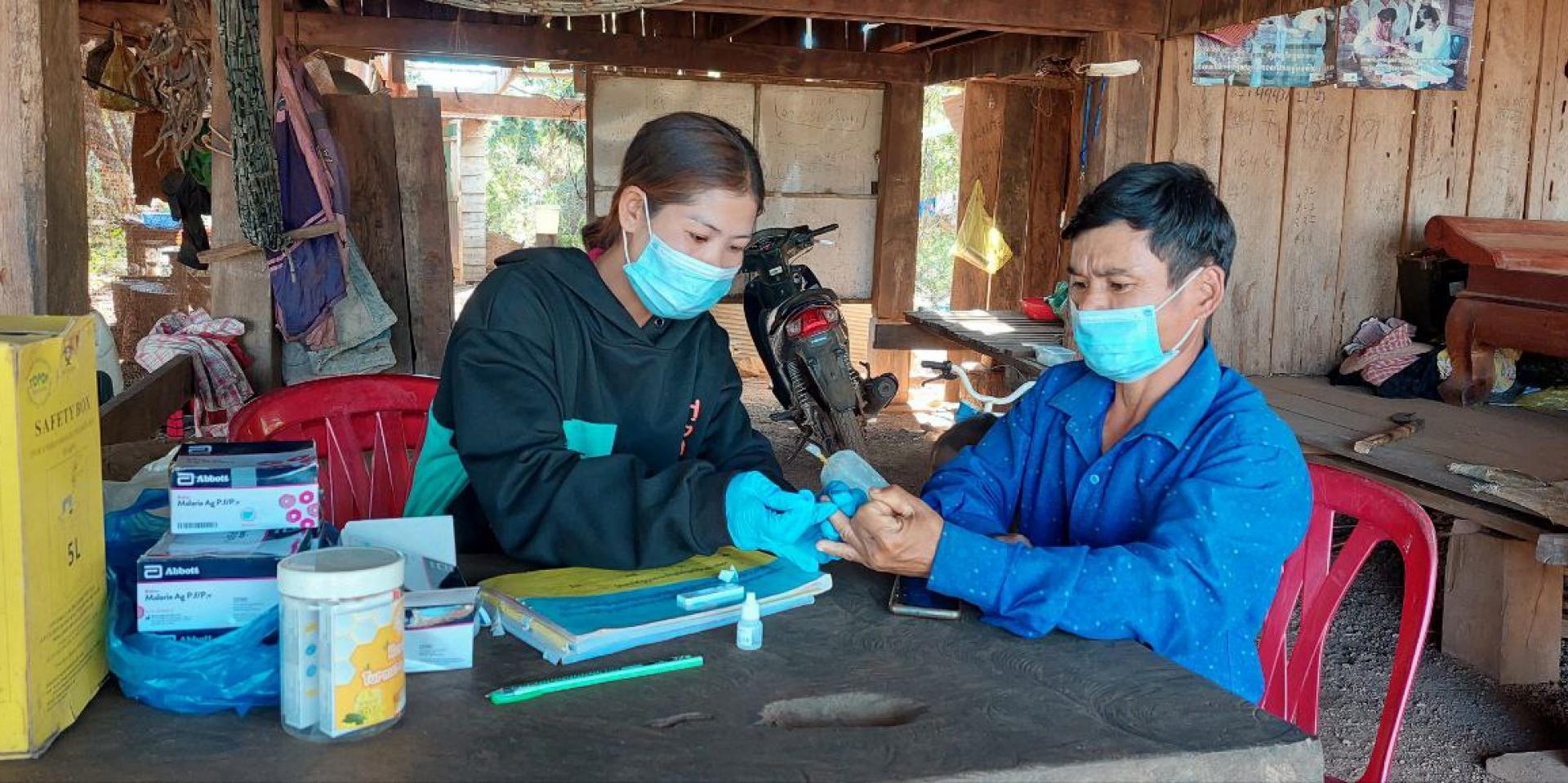 Village Malaria Worker Ms. Srey Touch conducts a malaria rapid diagnostic test in her village. Photo: UNOPS ARHC