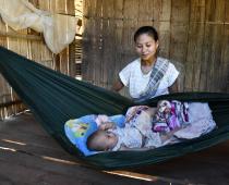 Naw Mu Lar watches over her baby, in their home on the Thai-Myanmar border, protected from mosquito bites and the risk of malaria. Photo: ARHC