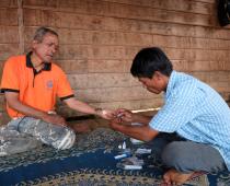 Village malaria worker Sisomphang testing a villager for malaria during a home visit. Photo: BART VERWEIJ