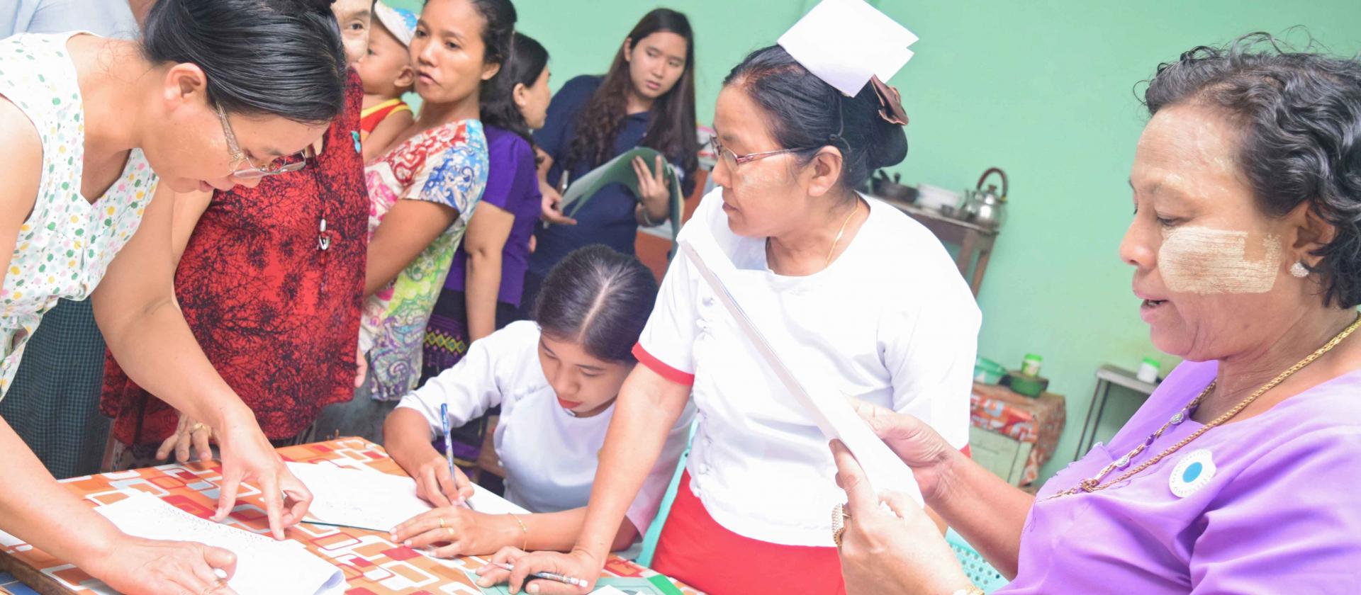 Daw Naw May, a midwife in Madauk Rural Health Centre, attends to registration for LLIN distribution. Photo: UNOPS