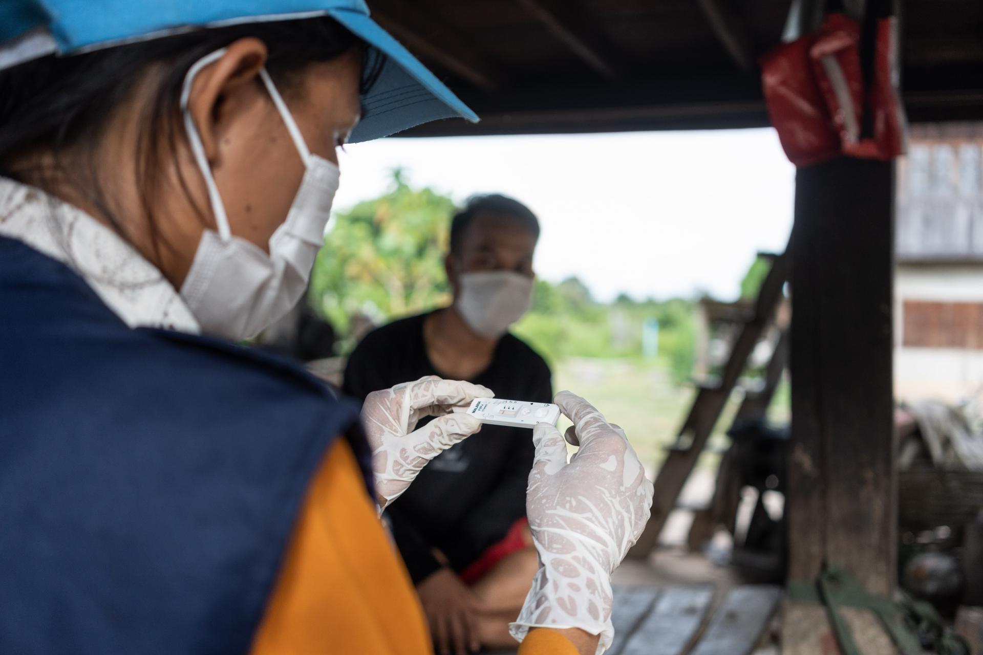 Village Malaria Worker Khounmy conducting a malaria test in her village. Photo: WHO/Enric Catala