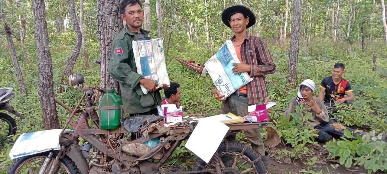 Forest-goers receive long-lasting insecticidal nets (LLIN) from mobile malaria worker, Mr Thong, during outreach activities in the forest near the Vietnamese border, Mondulkiri province. Photo: Malaria Consortium