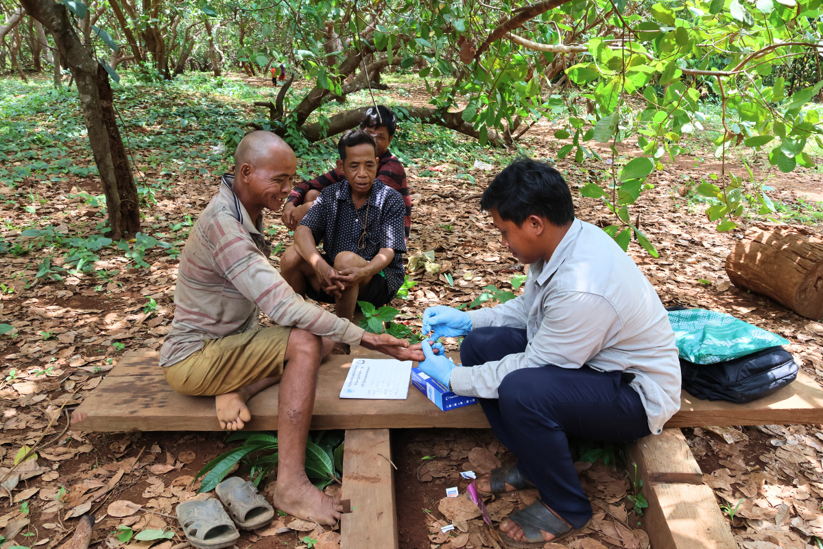 Mr. Meouy Buntear carries out a malaria test for workers who have just returned from the forest. Photo: Daneth Mao/ CRS