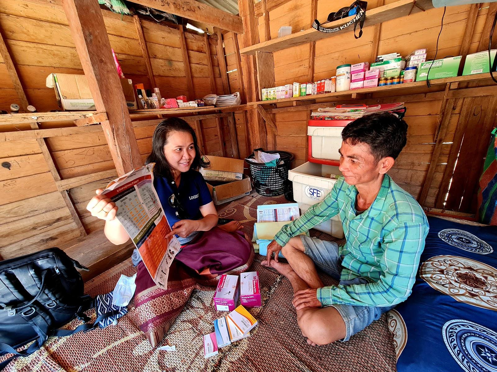 Dr. Manysai of Center for Malaria, Parasitology and Entomology, Lao PDR explains about the malaria treatment job aid to Mr. Viengkeo Phasavaeng of Paheung village. Photo: Dr. Yu Nandar Aung, UNOPS-Lao PDR