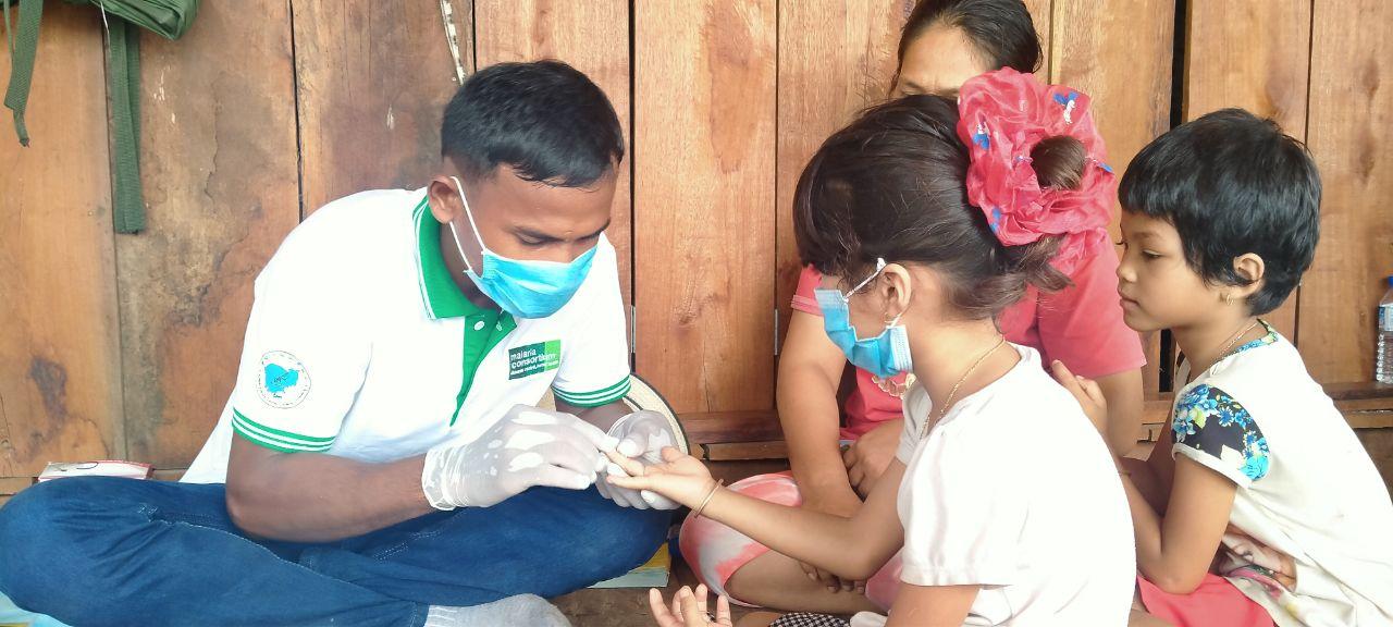 Mobile malaria worker, Horn, performs a malaria rapid diagnostic test (mRDT) for a child at her family home in Kbal Domrei village, Preah Vihear province. Photo: Malaria Consortium