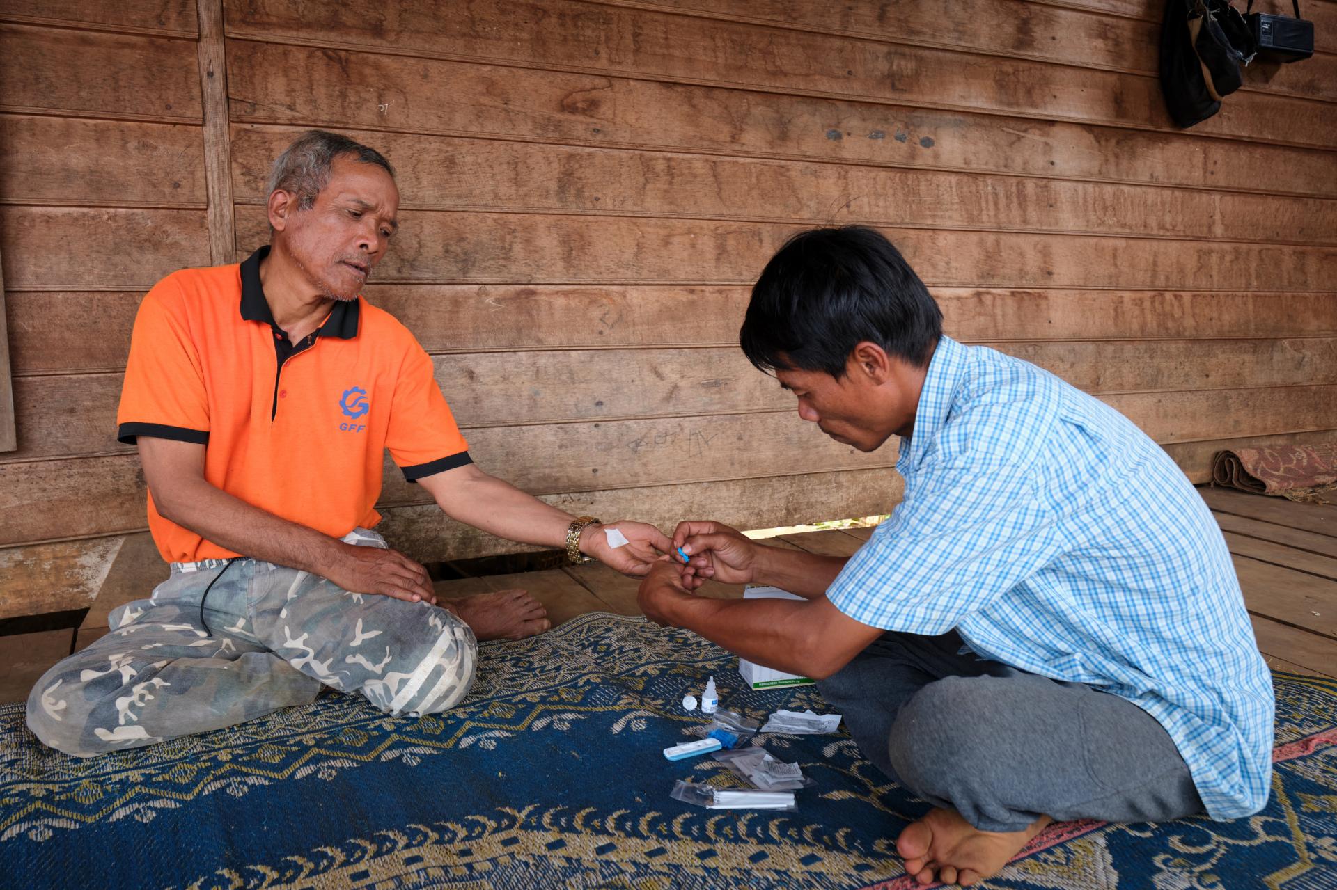 Village malaria worker Sisomphang testing a villager for malaria during a home visit. Photo: BART VERWEIJ