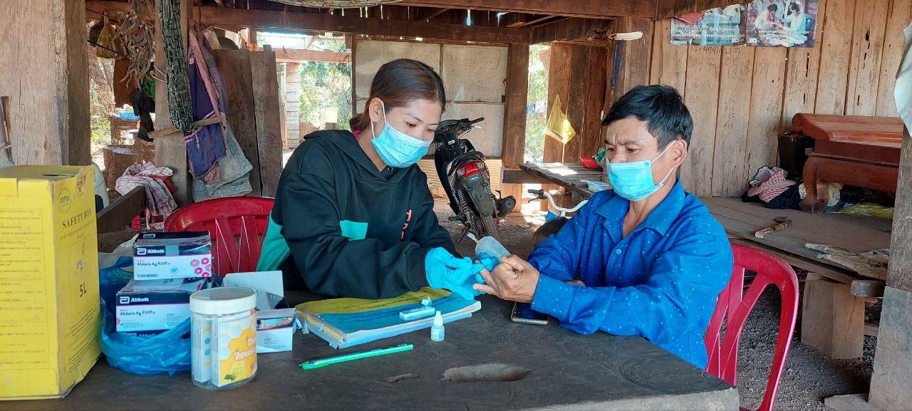 Village Malaria Worker Ms. Srey Touch conducts a malaria rapid diagnostic test in her village. Photo: UNOPS ARHC