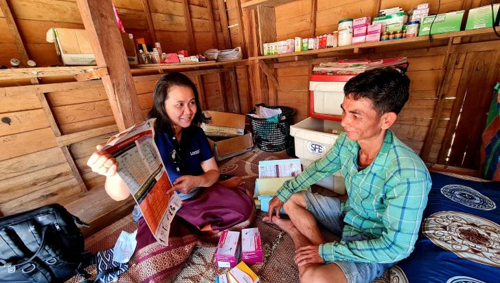 Dr. Manysai of Center for Malaria, Parasitology and Entomology, Lao PDR explains about the malaria treatment job aid to Mr. Viengkeo Phasavaeng of Paheung village. Photo: Dr. Yu Nandar Aung, UNOPS-Lao PDR