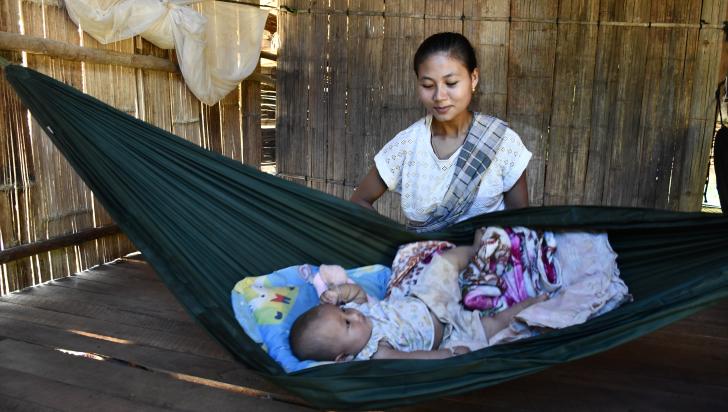 Naw Mu Lar watches over her baby, in their home on the Thai-Myanmar border, protected from mosquito bites and the risk of malaria. Photo: ARHC