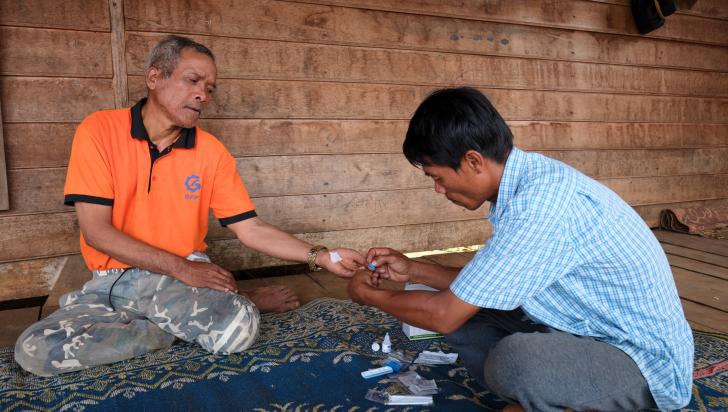 Village malaria worker Sisomphang testing a villager for malaria during a home visit. Photo: BART VERWEIJ