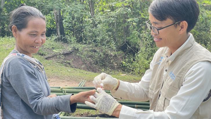 Volunteer malaria worker Ho Van Than draws a blood sample from a forest-goer to perform a malaria rapid diagnostic test in Xy Commune, Viet Nam. Photo: HPA