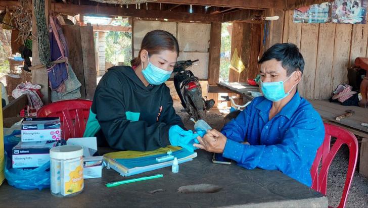 Village Malaria Worker Ms. Srey Touch conducts a malaria rapid diagnostic test in her village. Photo: UNOPS ARHC