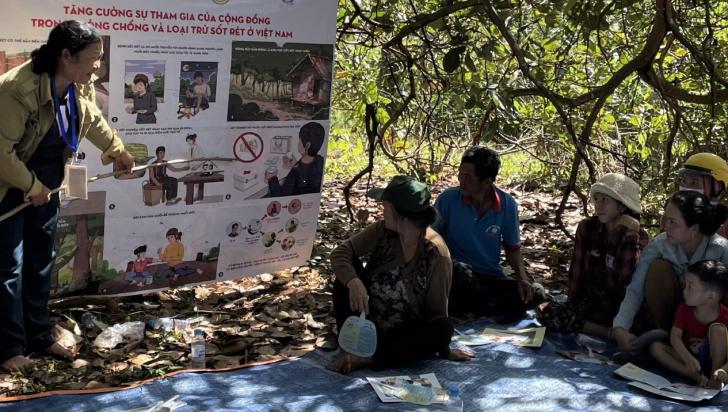 A community health worker, trained and supported by civil society organizations, conducts a group discussion in the forest with individuals at risk of malaria due to their forest-foraging and farming activities in Binh Phuoc province, near Viet Nam's border with Cambodia. Photo: Josselyn Neukom